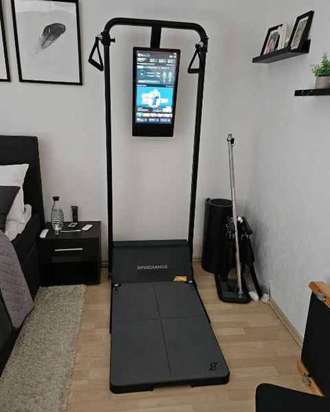 A Gym Monster in a bedroom beside a bed and shelves