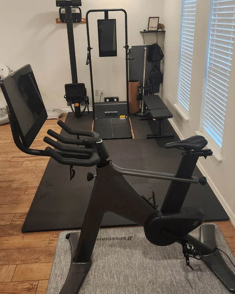 A Gym Monster in a home gym with an exercise bike and a bench