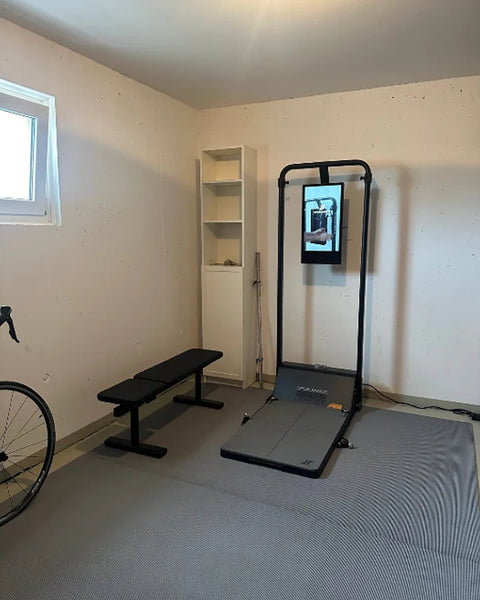 A Gym Monster in a bright spare room with a bench and a bike