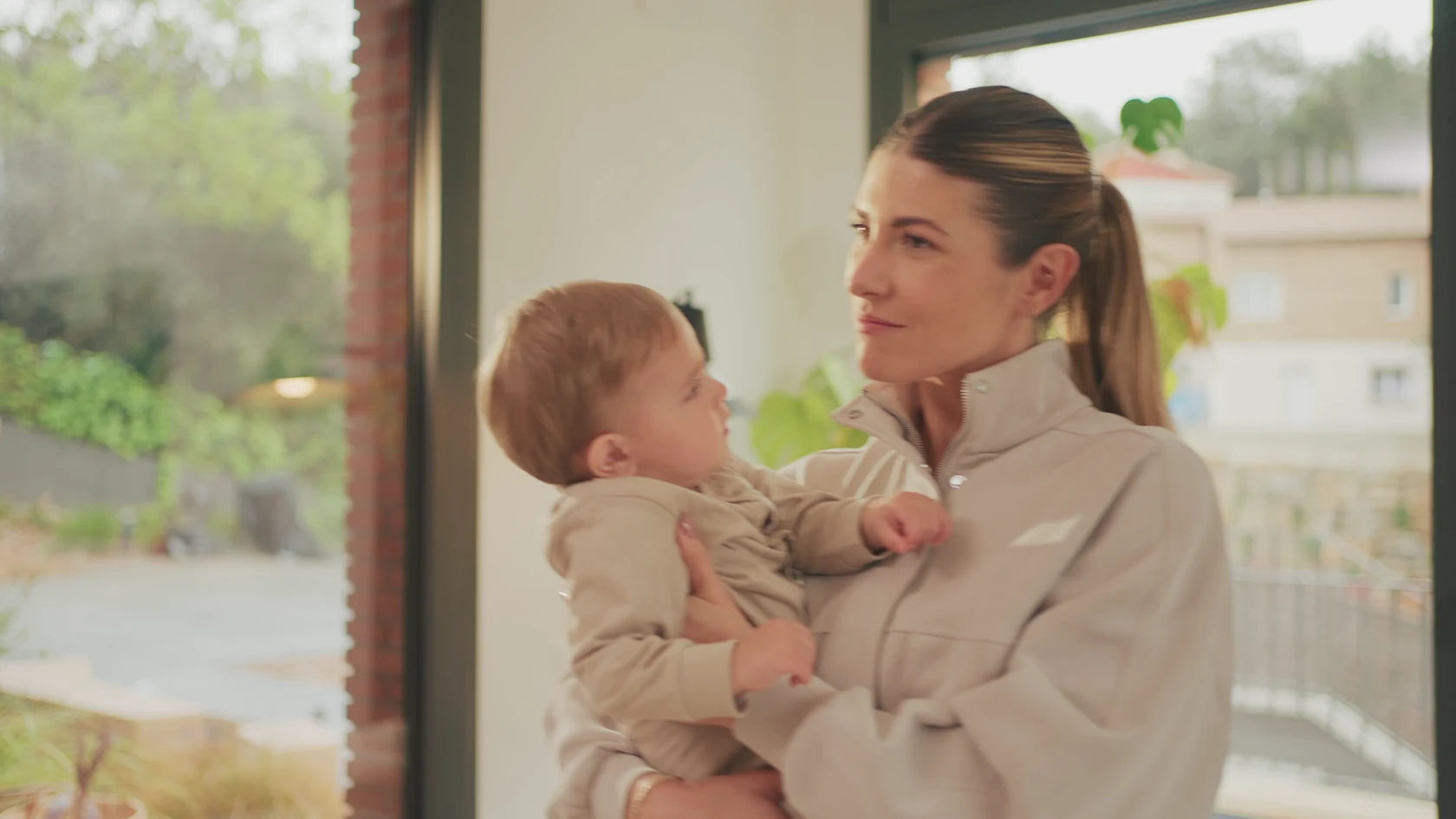 Een moeder deelt een rustig moment met haar baby thuis, uit Speediance's familiefilm
